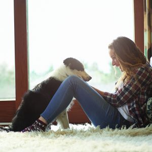 Profile of woman sitting in lounge with dog.